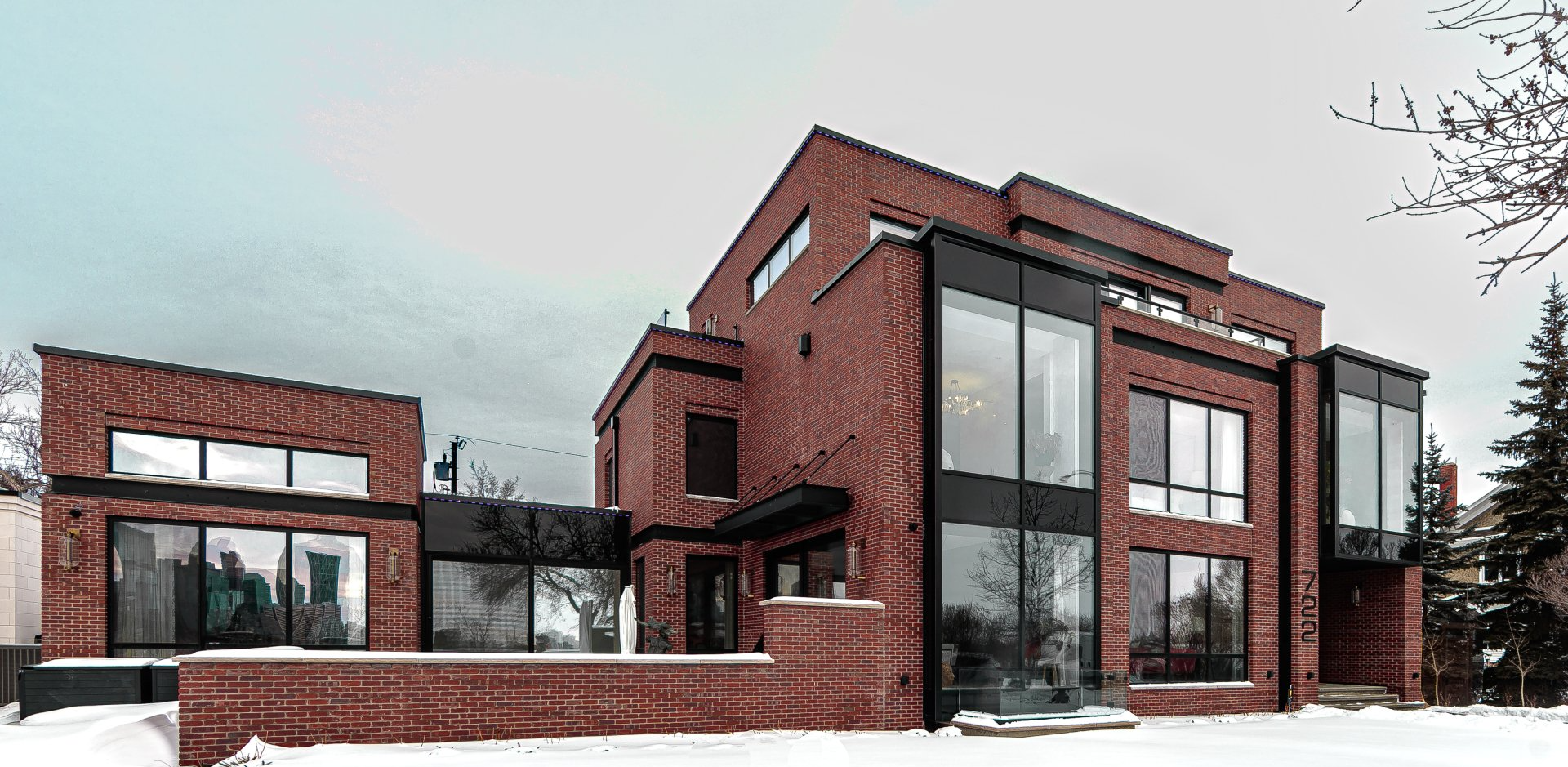 a large brick house with a lot of windows is covered in snow .