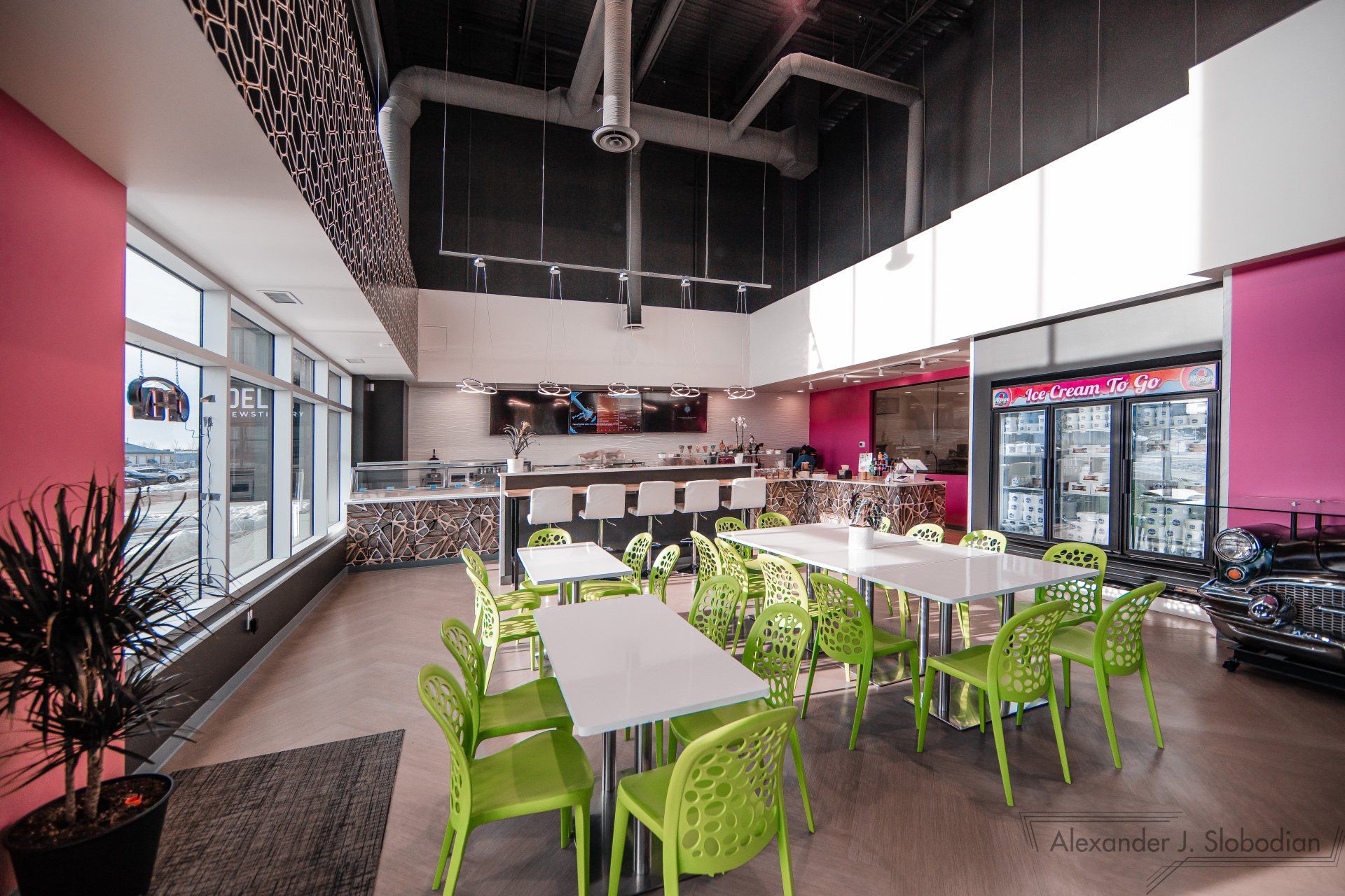 a restaurant with green chairs and white tables