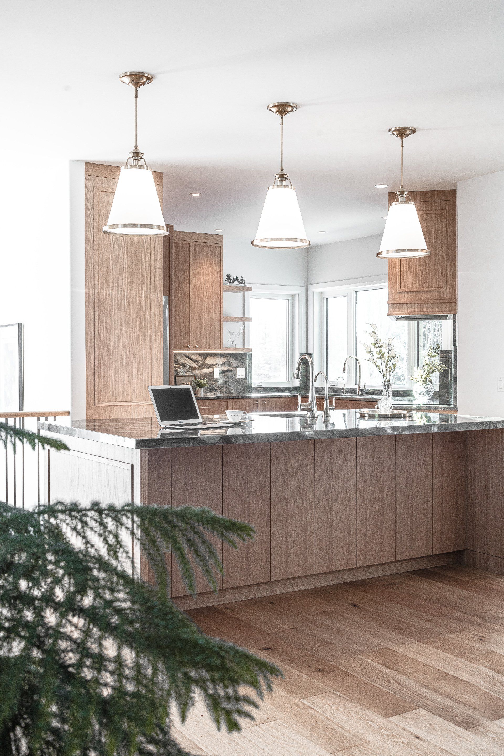 a kitchen with a large island and a laptop on the counter .