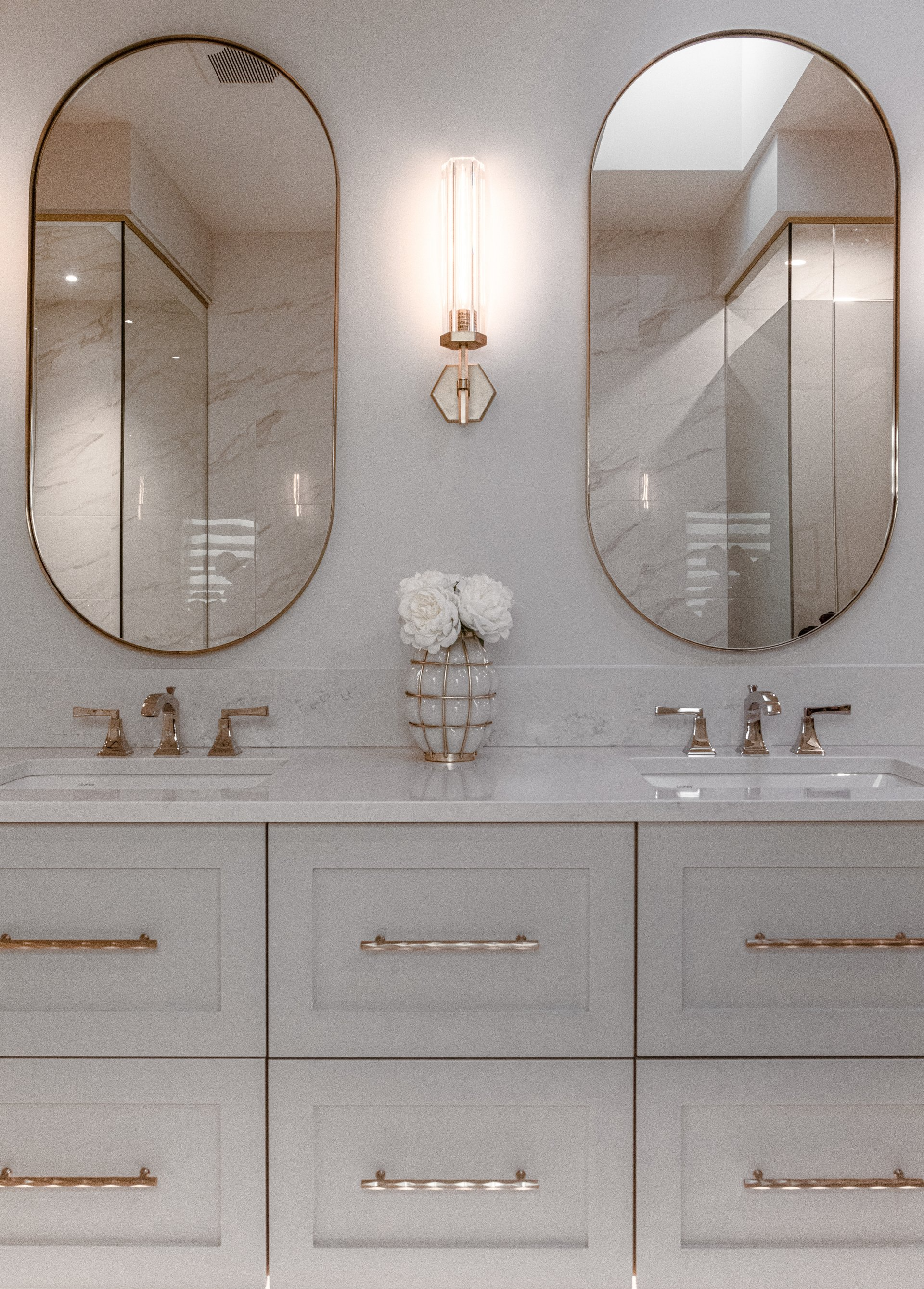 a bathroom with two sinks and two mirrors