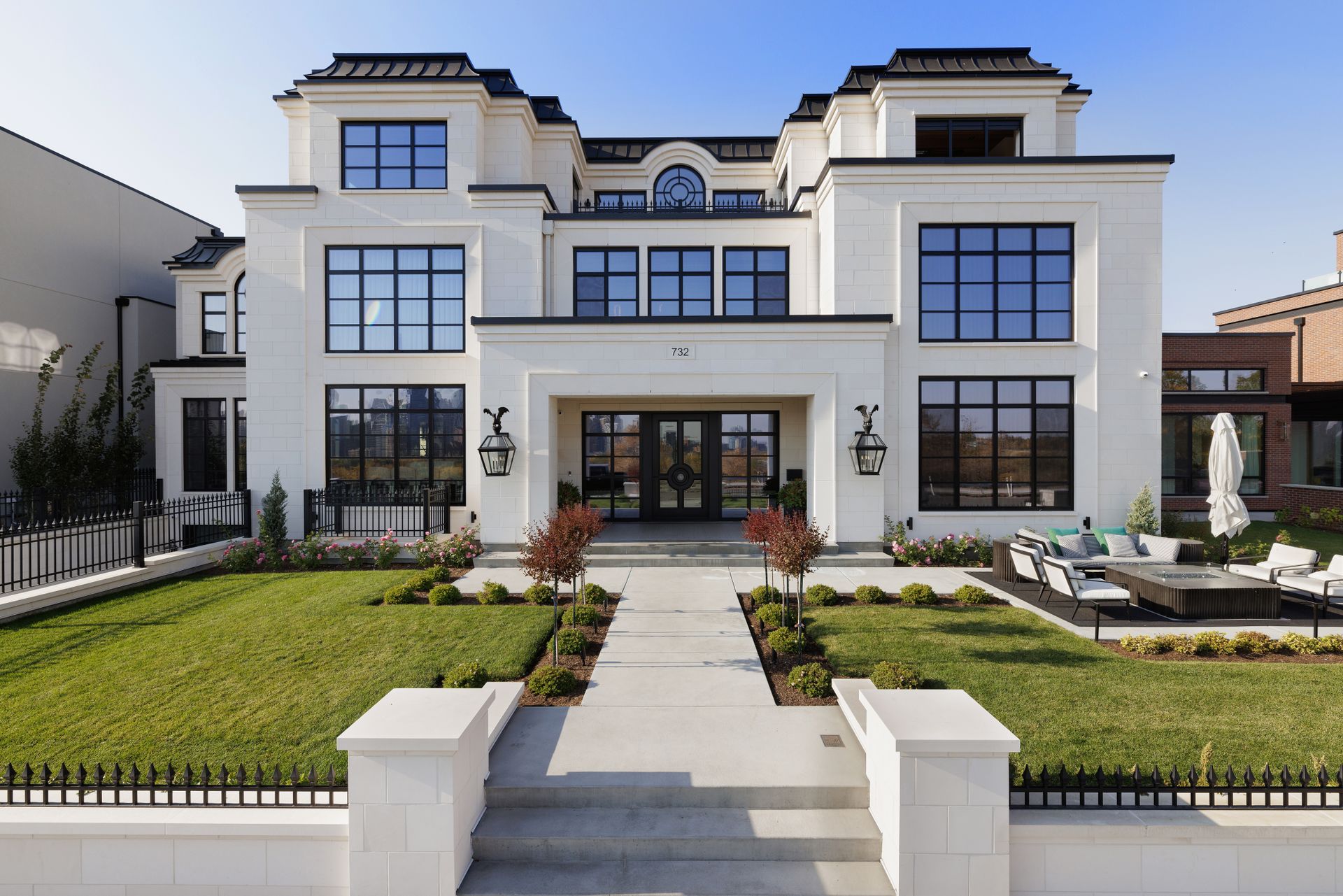 a large white house with a lot of windows and a fence in front of it .