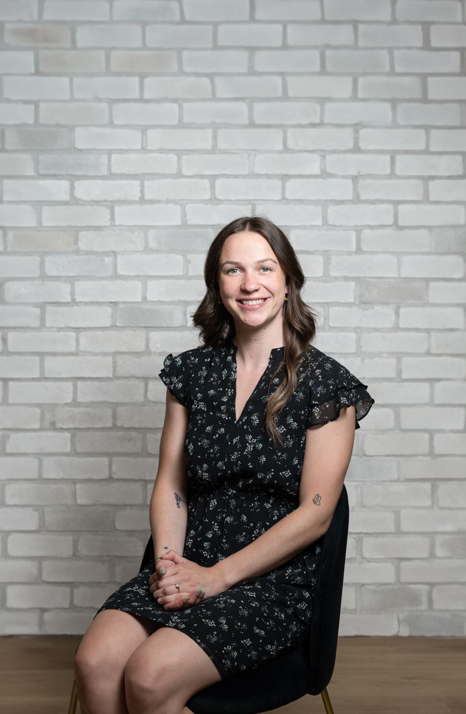 a man is sitting on a chair in front of a brick wall .