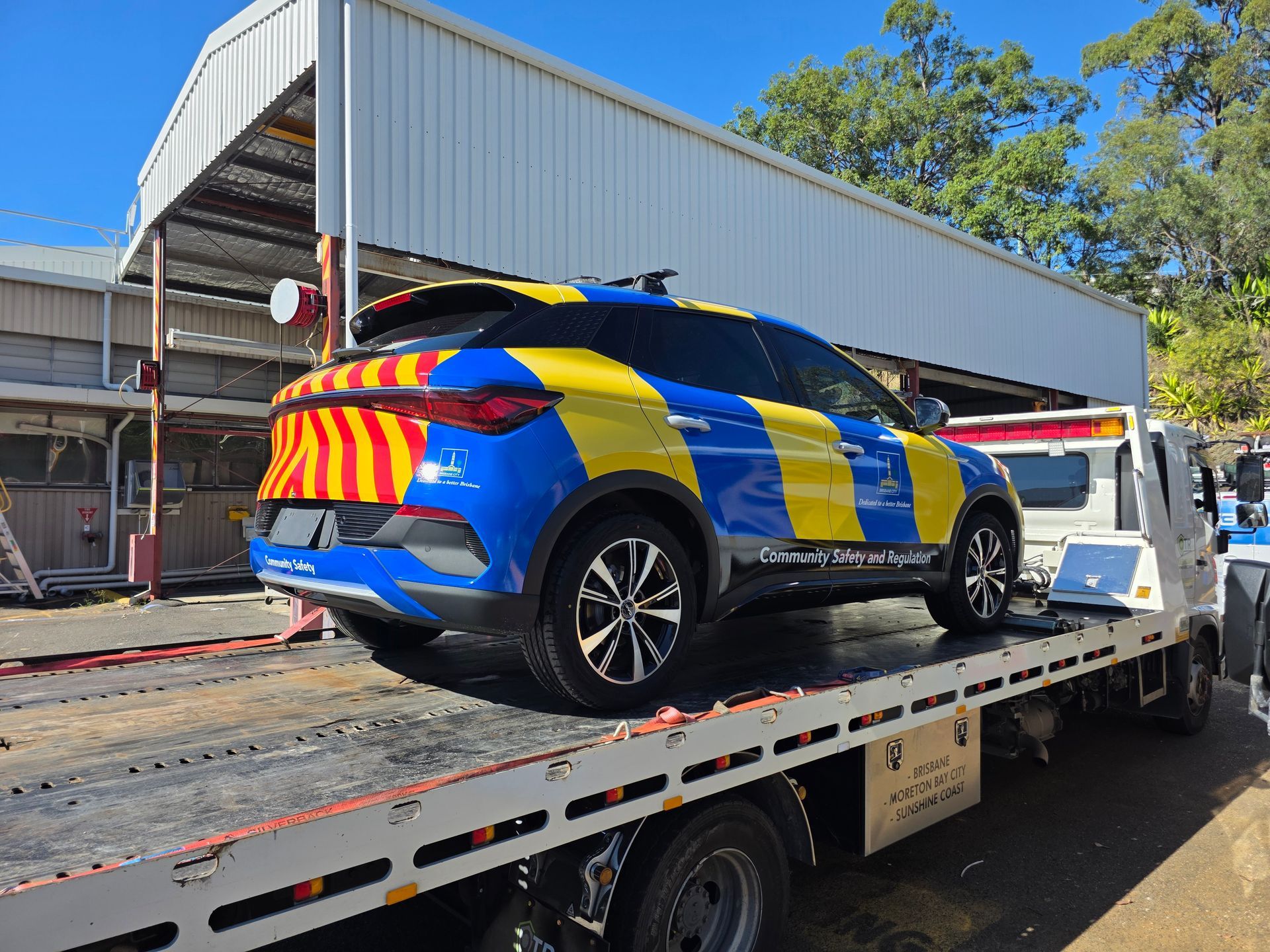 A white tow truck is parked on the side of the road.
