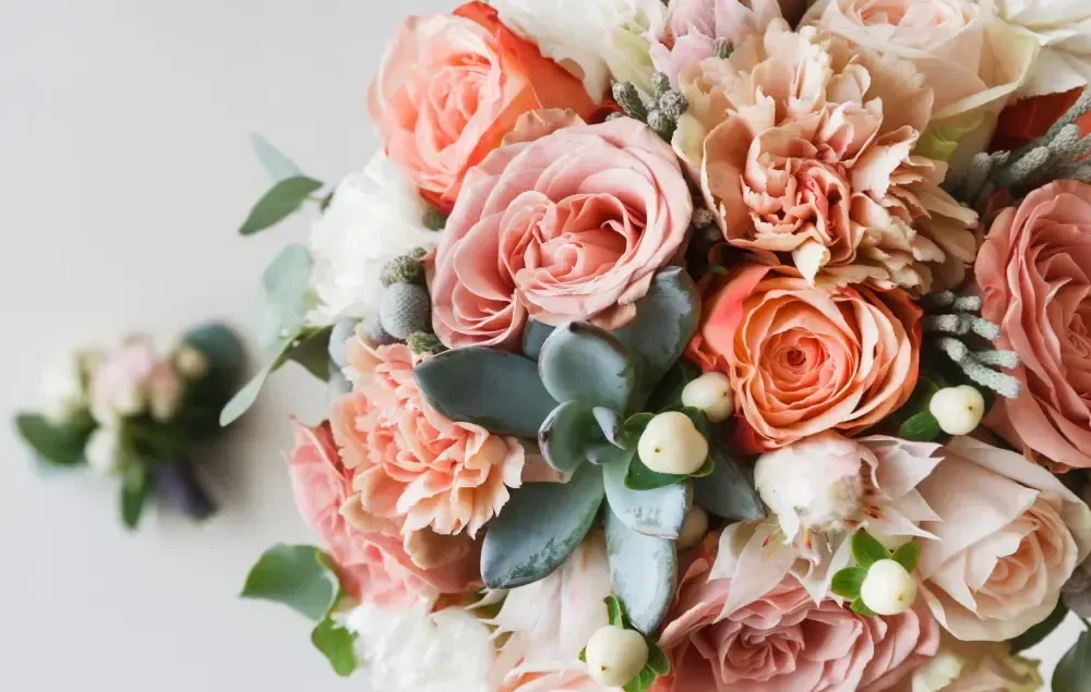 A close up of a bouquet of flowers on a table.