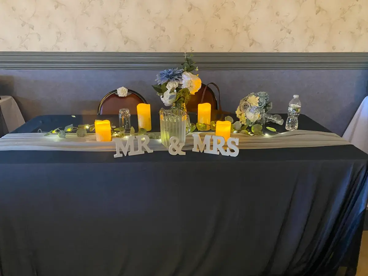 A table with candles and flowers on it and a sign that says mr. and mrs.