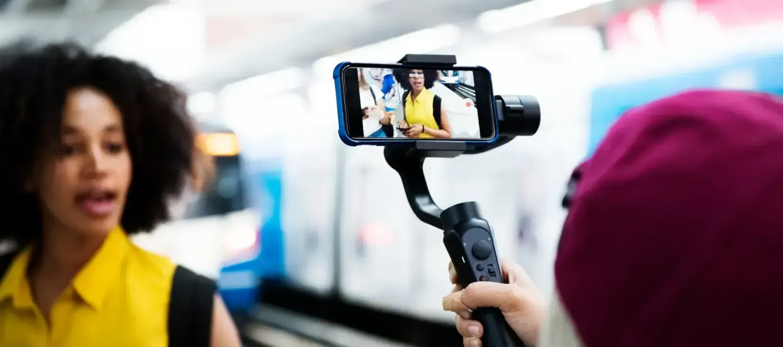 A person is taking a picture of a woman with a cell phone.