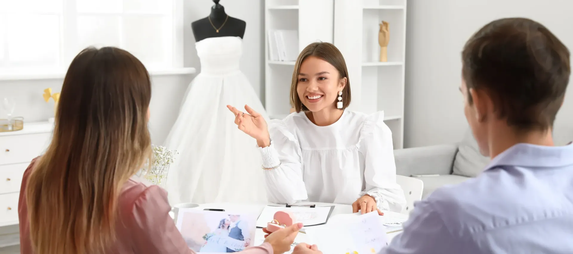 A woman is sitting at a table talking to a man and a woman.