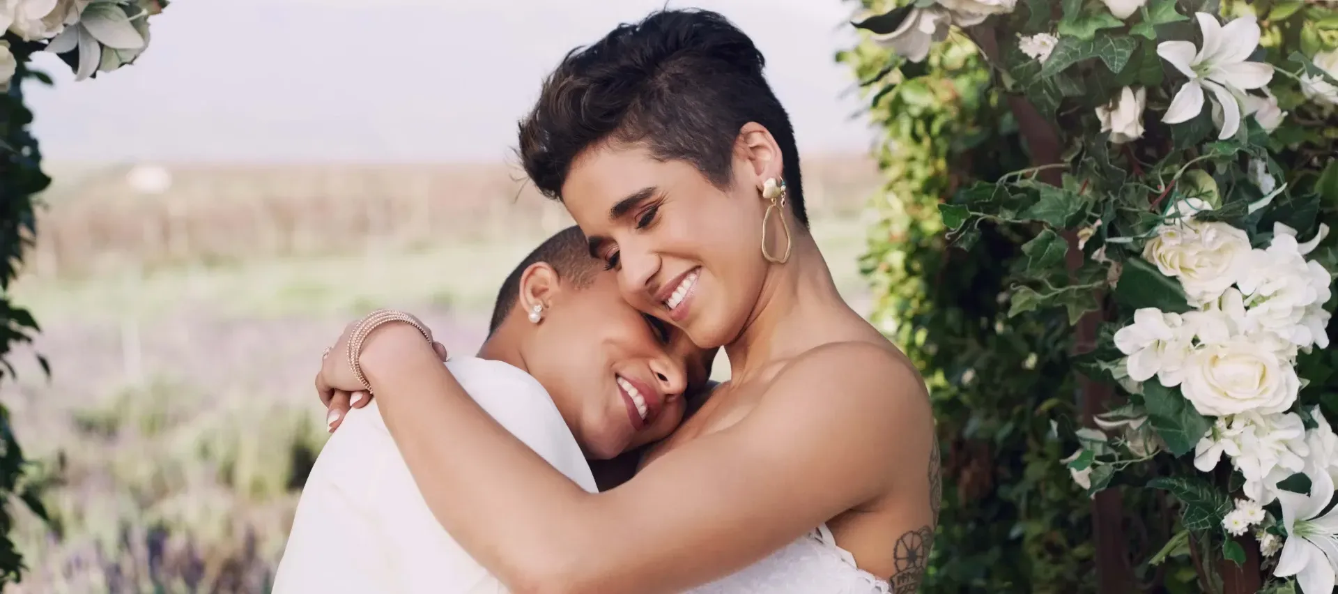 brides are hugging each other in a field.