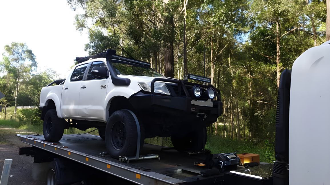A White Truck Is Sitting On Top Of A Tow Truck — NCM Towing Newcastle In Nelson Bay, NSW