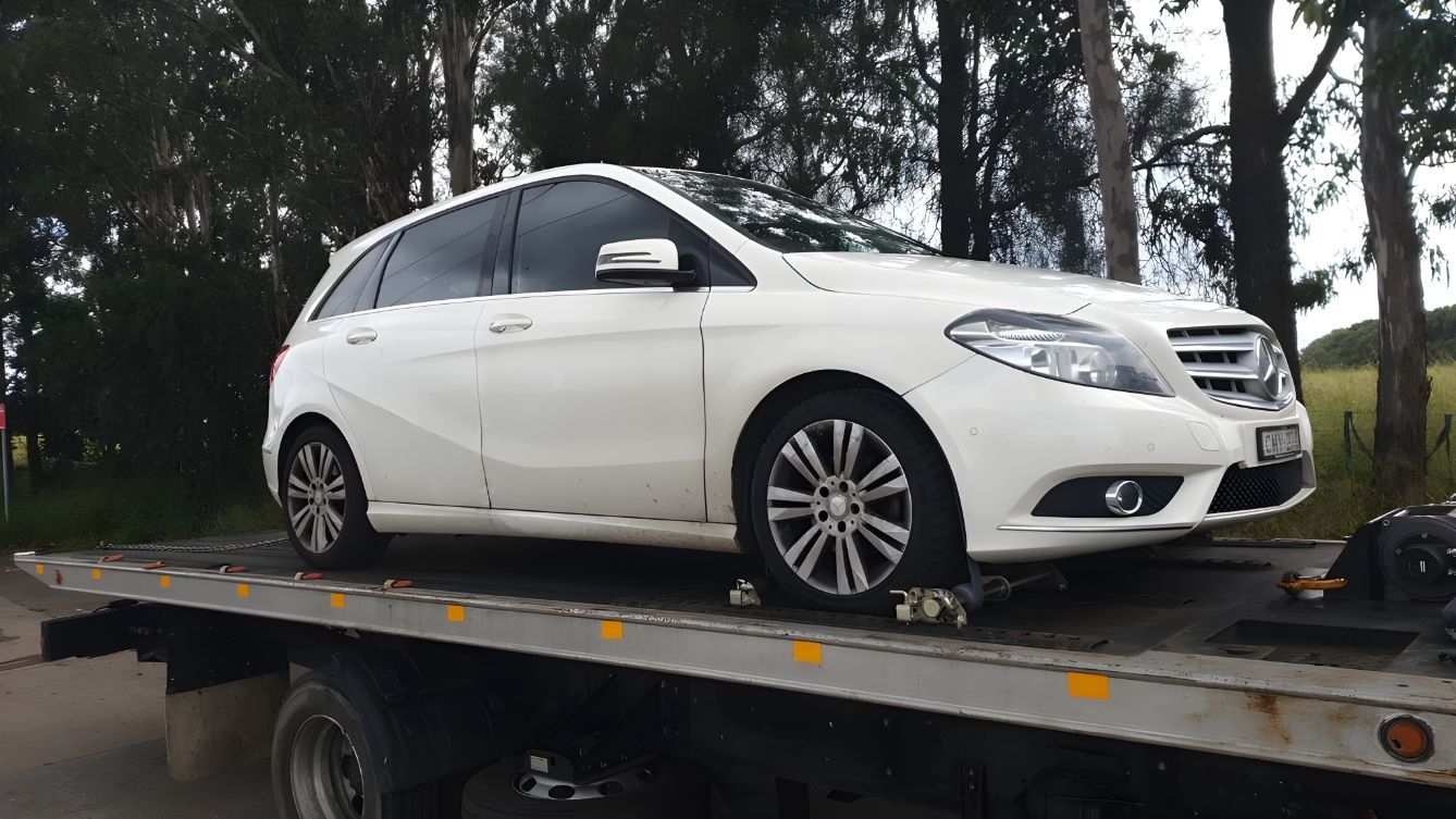 A White Car Is Sitting On Top Of A Tow Truck — NCM Towing Newcastle In Cessnock, NSW