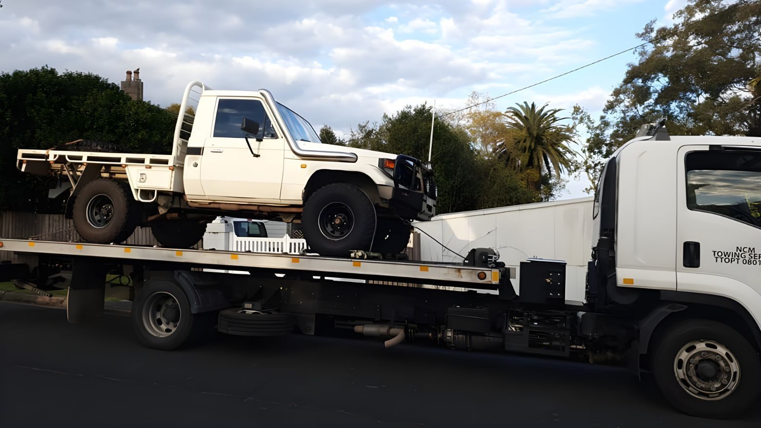 A Tow Truck Is Carrying A Truck On The Back Of It — NCM Towing Newcastle In Port Stephens, NSW