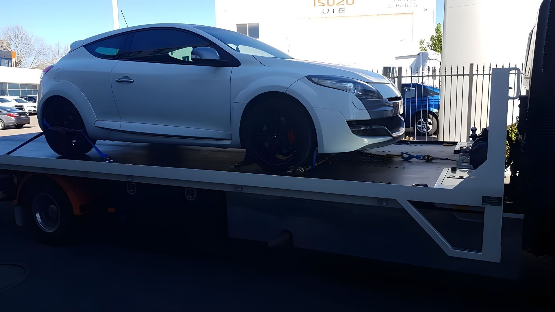 A White Car Is Sitting On Top Of A Tow Truck — NCM Towing Newcastle In Toronto, NSW