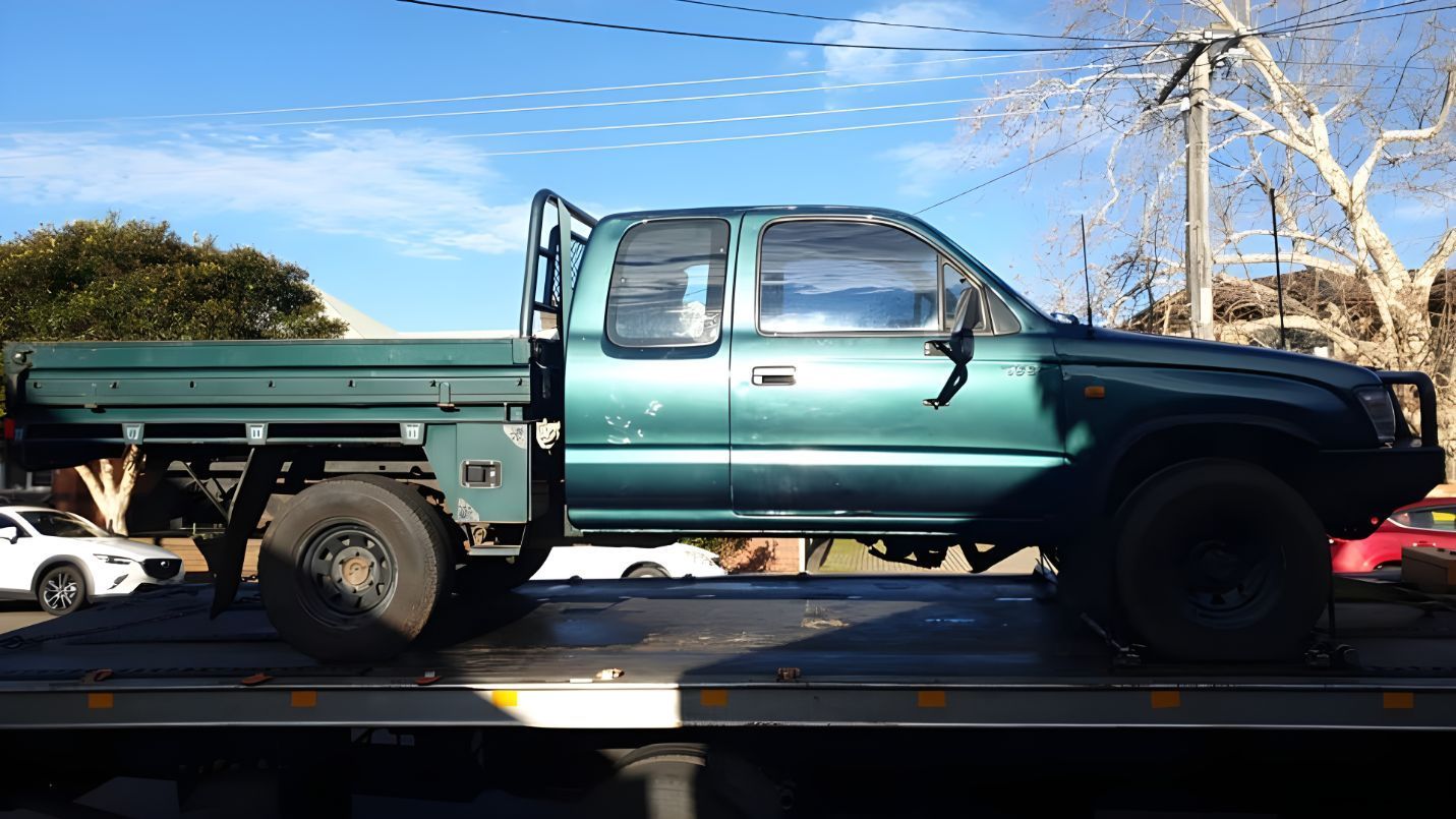 A Green Truck Is Sitting On Top Of A Tow Truck — NCM Towing Newcastle In Sydney, NSW