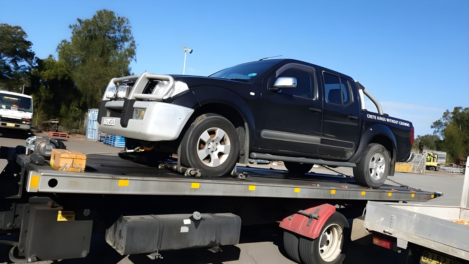 A Black Truck Is Sitting On Top Of A Tow Truck — NCM Towing Newcastle In Newcastle, NSW