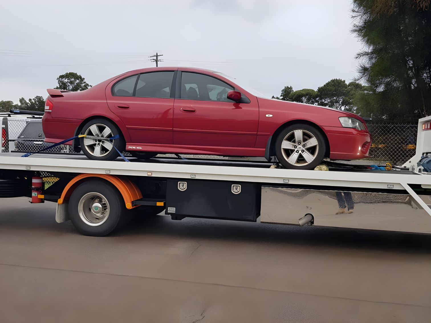 A Red Car Is Sitting On Top Of A Tow Truck — NCM Towing Newcastle In Hunter Valley, NSW