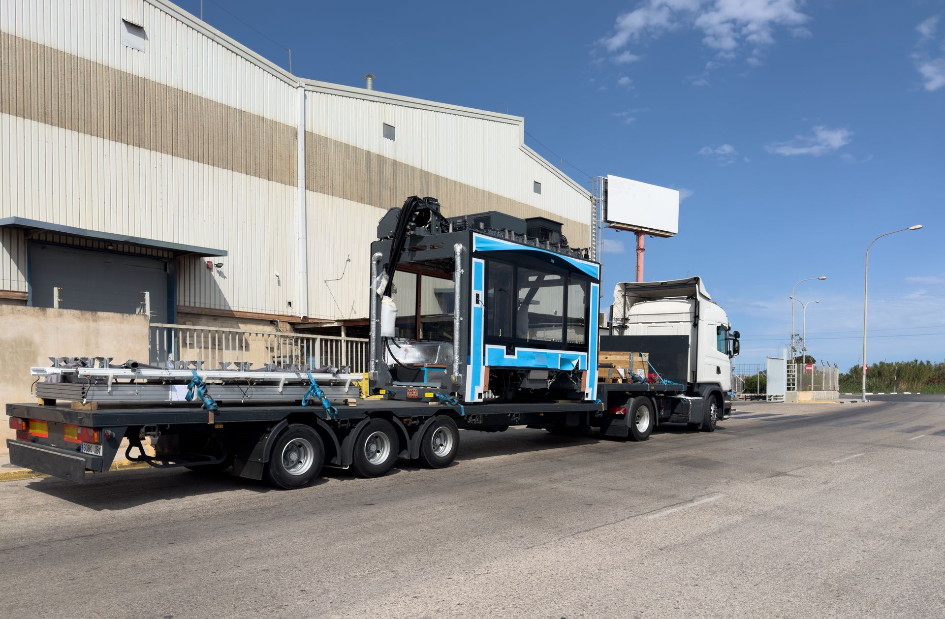 Truck Carrying Machinery and Metal Beams — NCM Towing Newcastle In Broadmeadow, NSW
