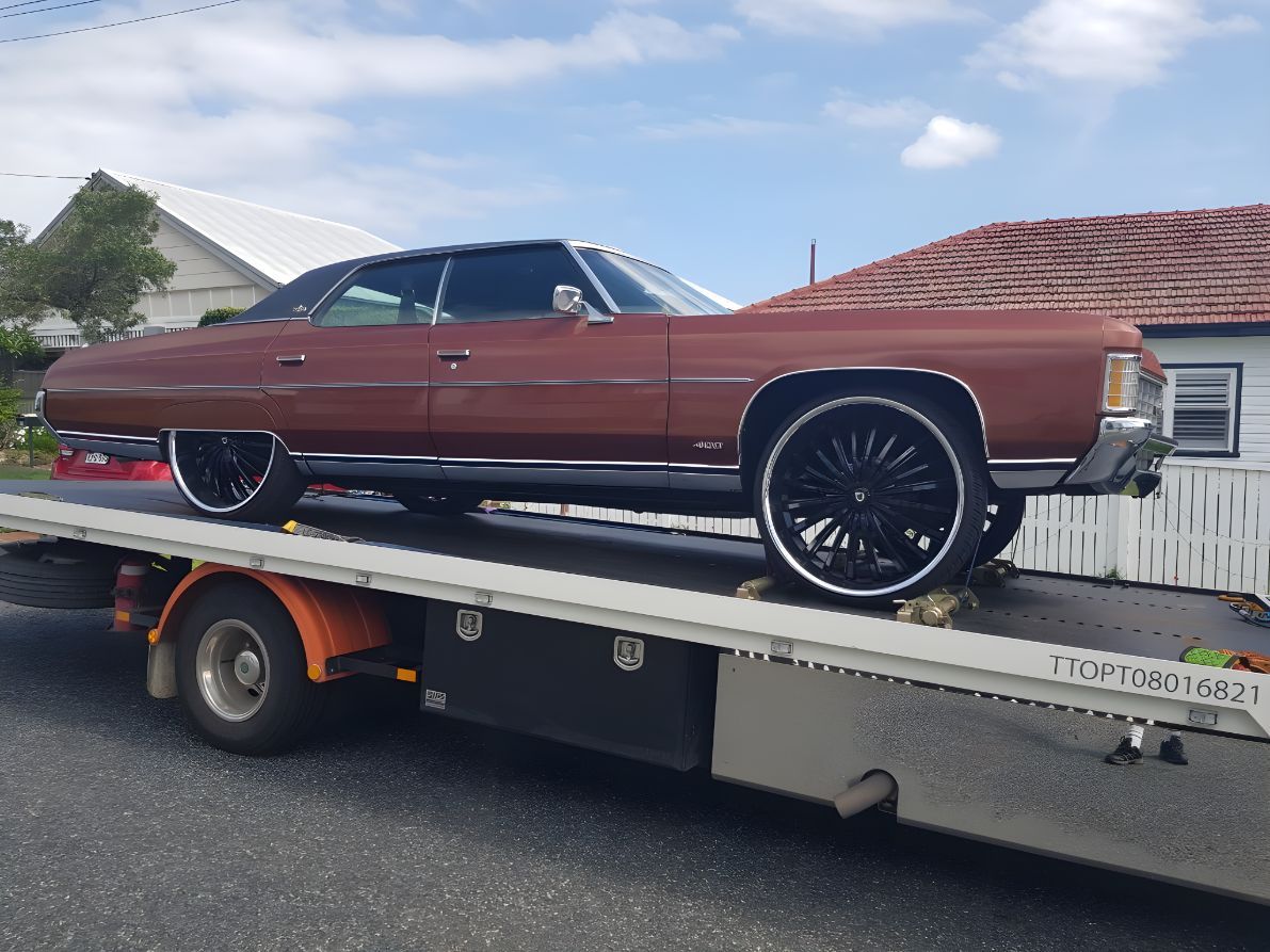 A Brown Car Is Sitting On Top Of A Tow Truck — NCM Towing Newcastle In Medowie, NSW
