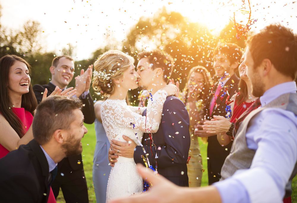 Newlyweds Kissing Outdoors, Surrounded by Celebrating Guests and Confetti — Coastal Vibez In The Entrance, NSW