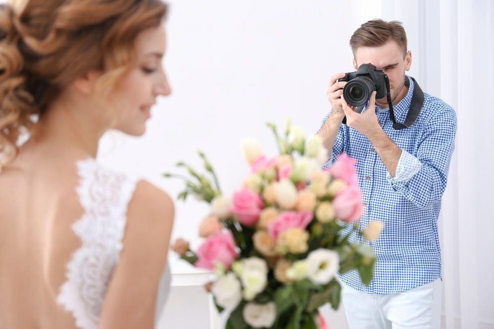 Photographer Taking a Photo of a Woman Holding Flowers in a Bright Room — Coastal Vibez In Sydney, NSW