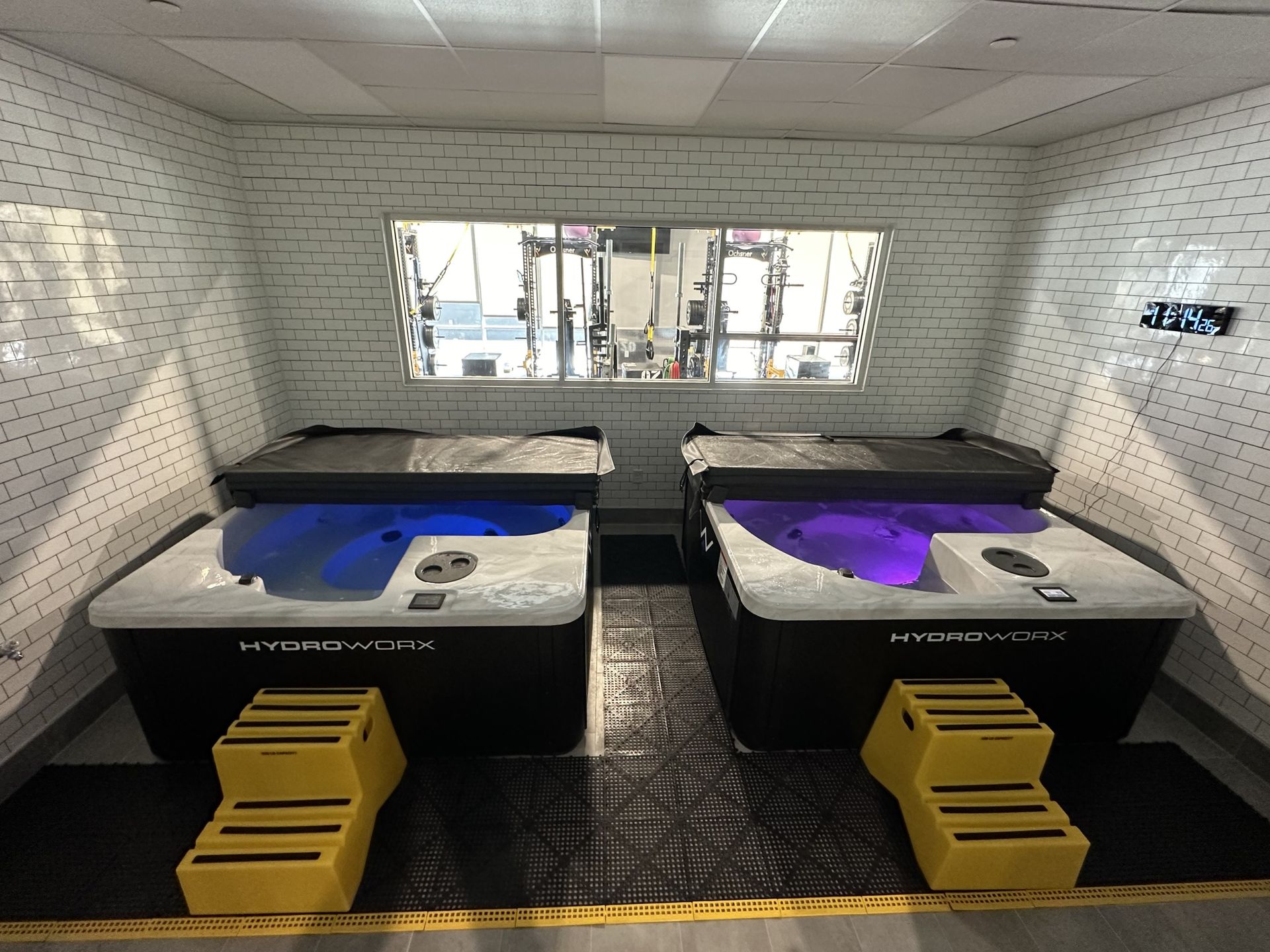 A sauna is sitting in a hallway next to a wooden floor.