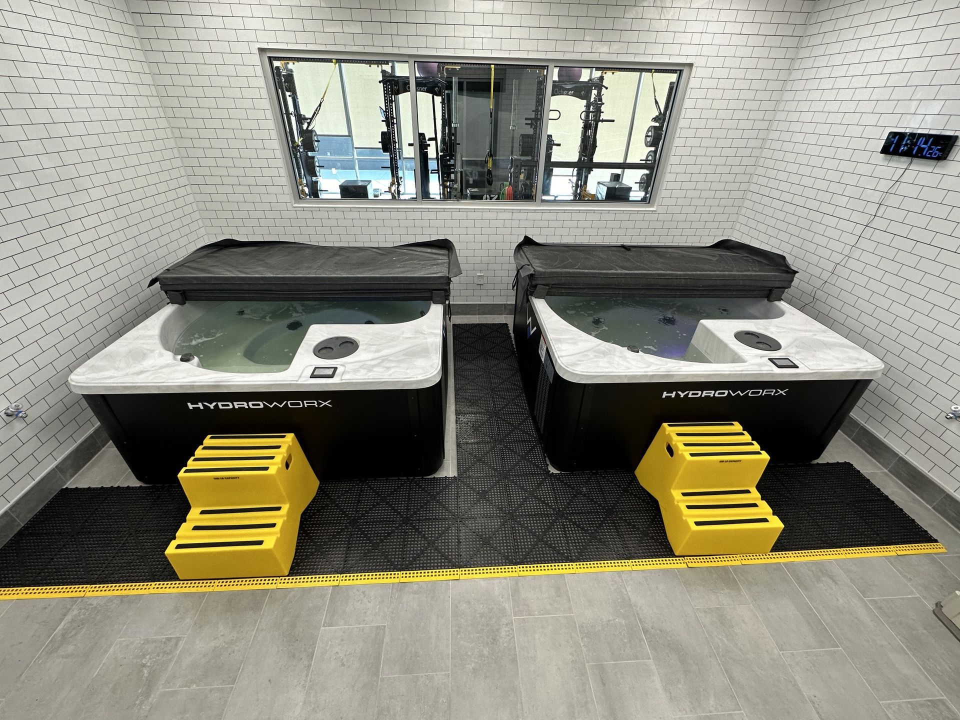 Two hot tubs are sitting next to each other in a room.