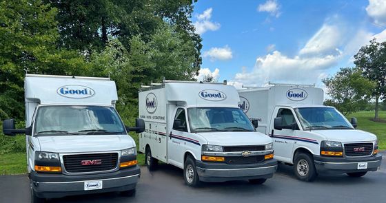 Three white service vans parked, with the