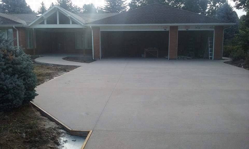 A house with a concrete driveway in front of it.