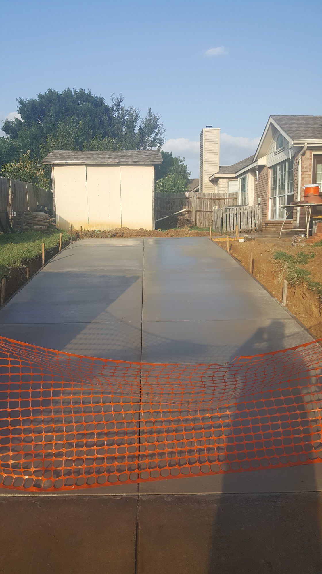 A concrete driveway is being built in front of a house.