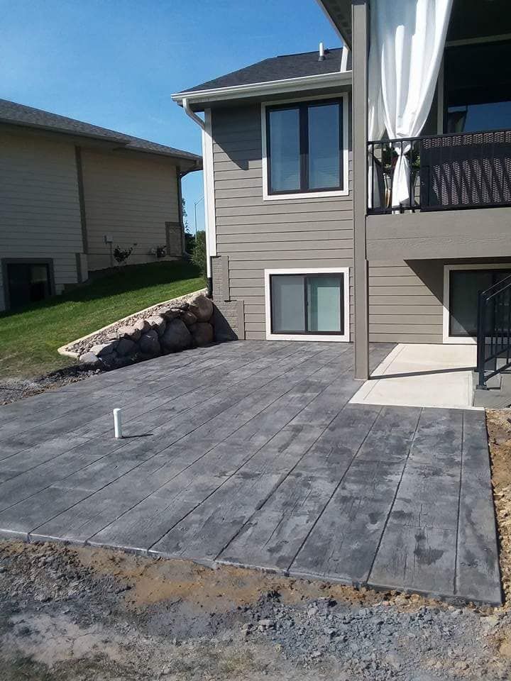 A house with a patio in front of it and a balcony.