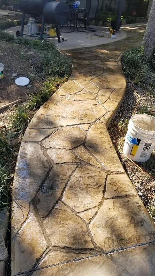 A concrete walkway with a bucket on the side of it.