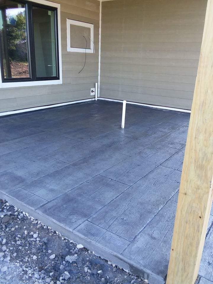 A concrete patio is being built in front of a house.