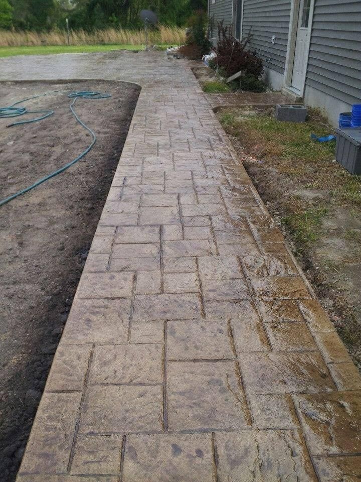 A concrete walkway is being built in front of a house.