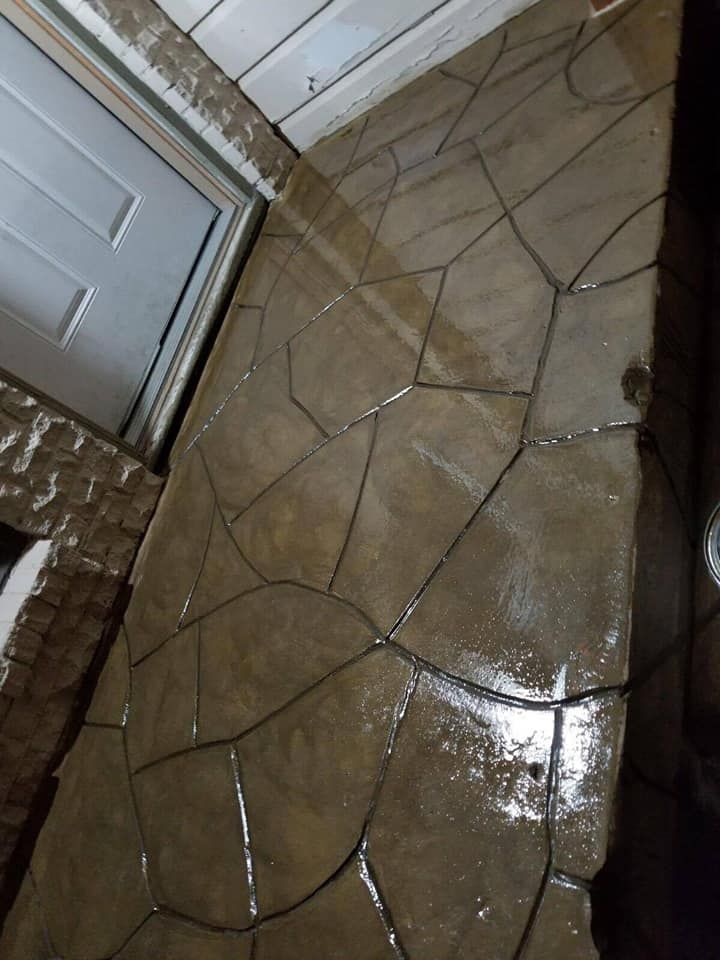 A concrete floor with a geometric pattern and a door in the background.