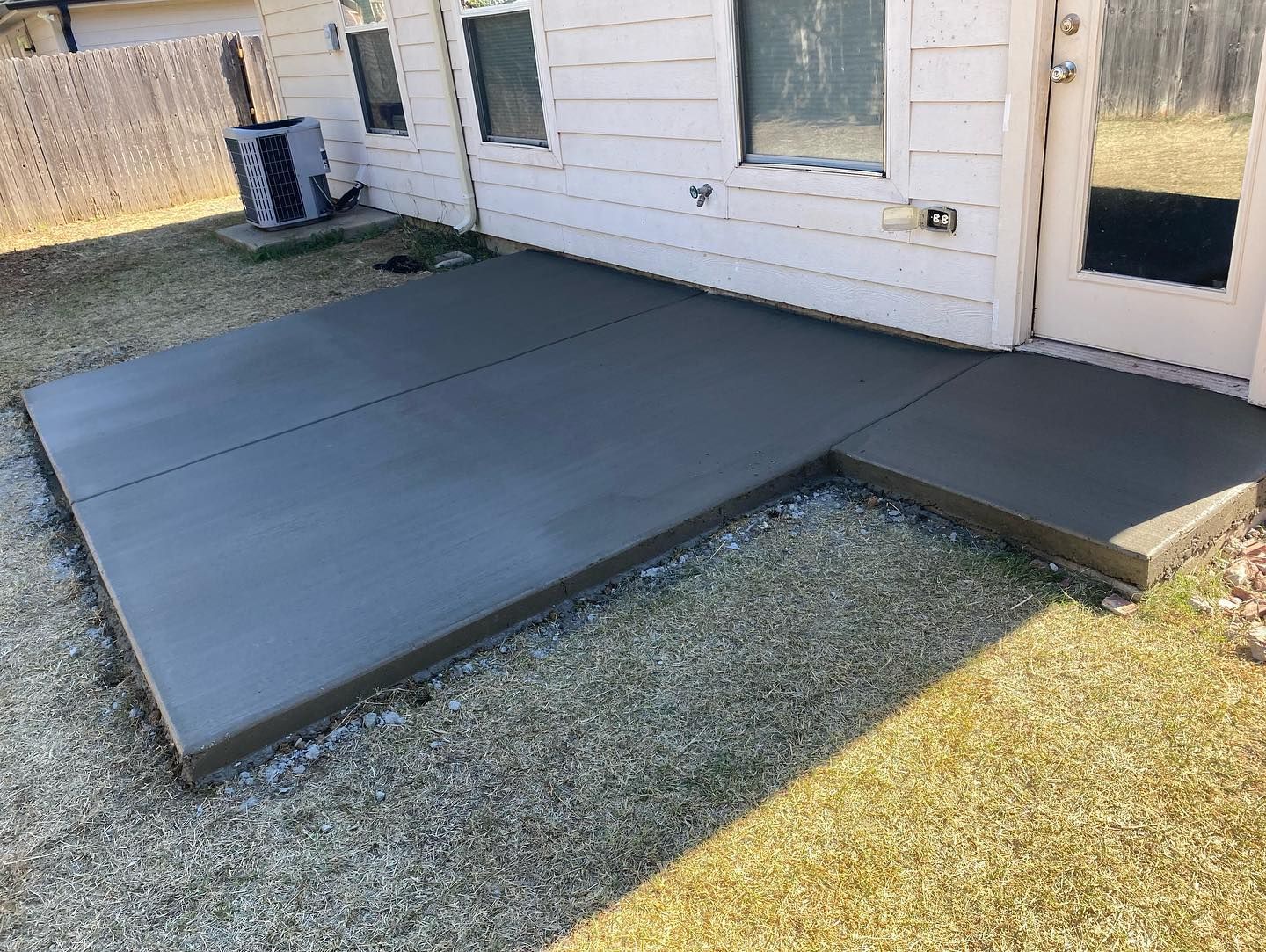 A concrete walkway is being built in front of a house.
