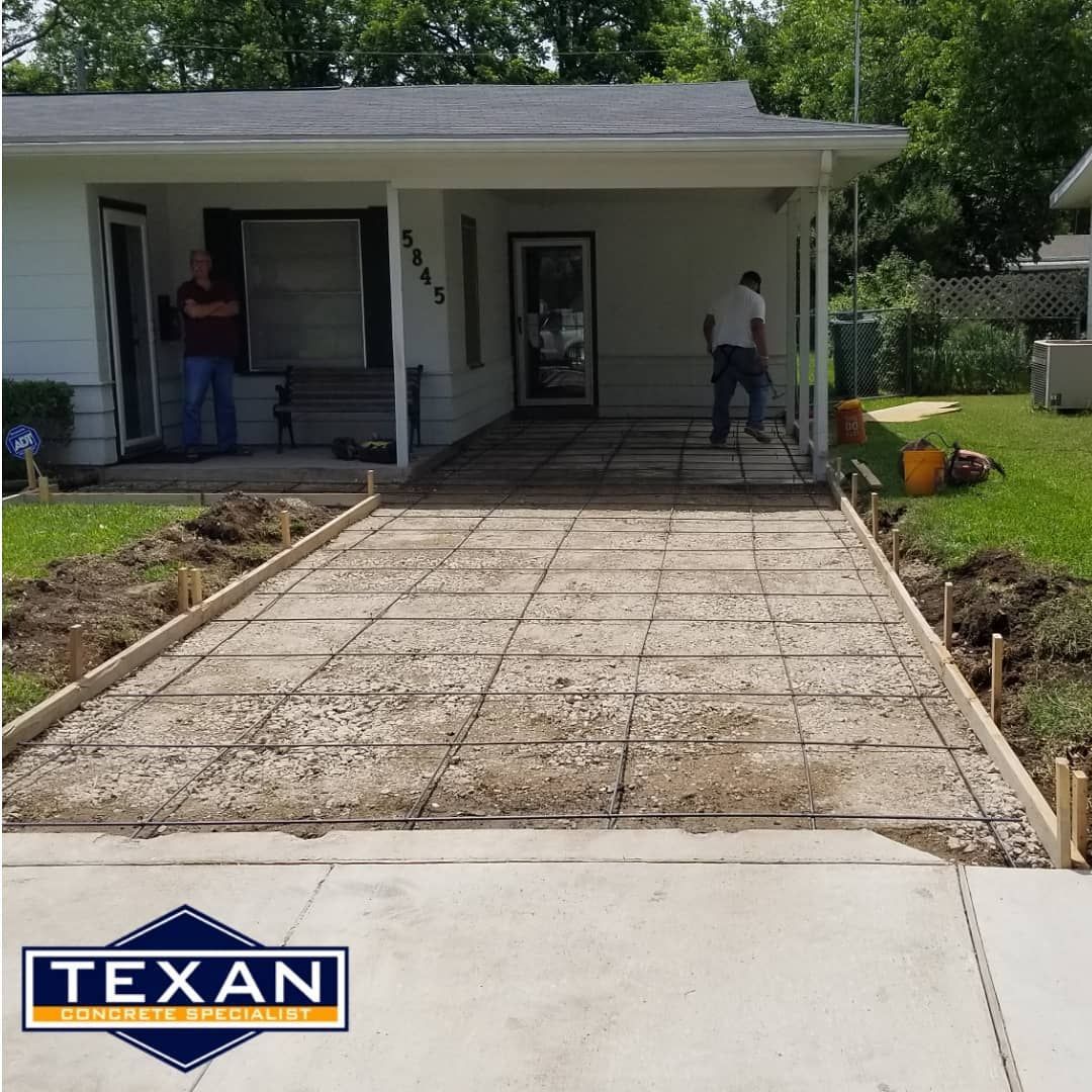 A concrete driveway is being built in front of a house