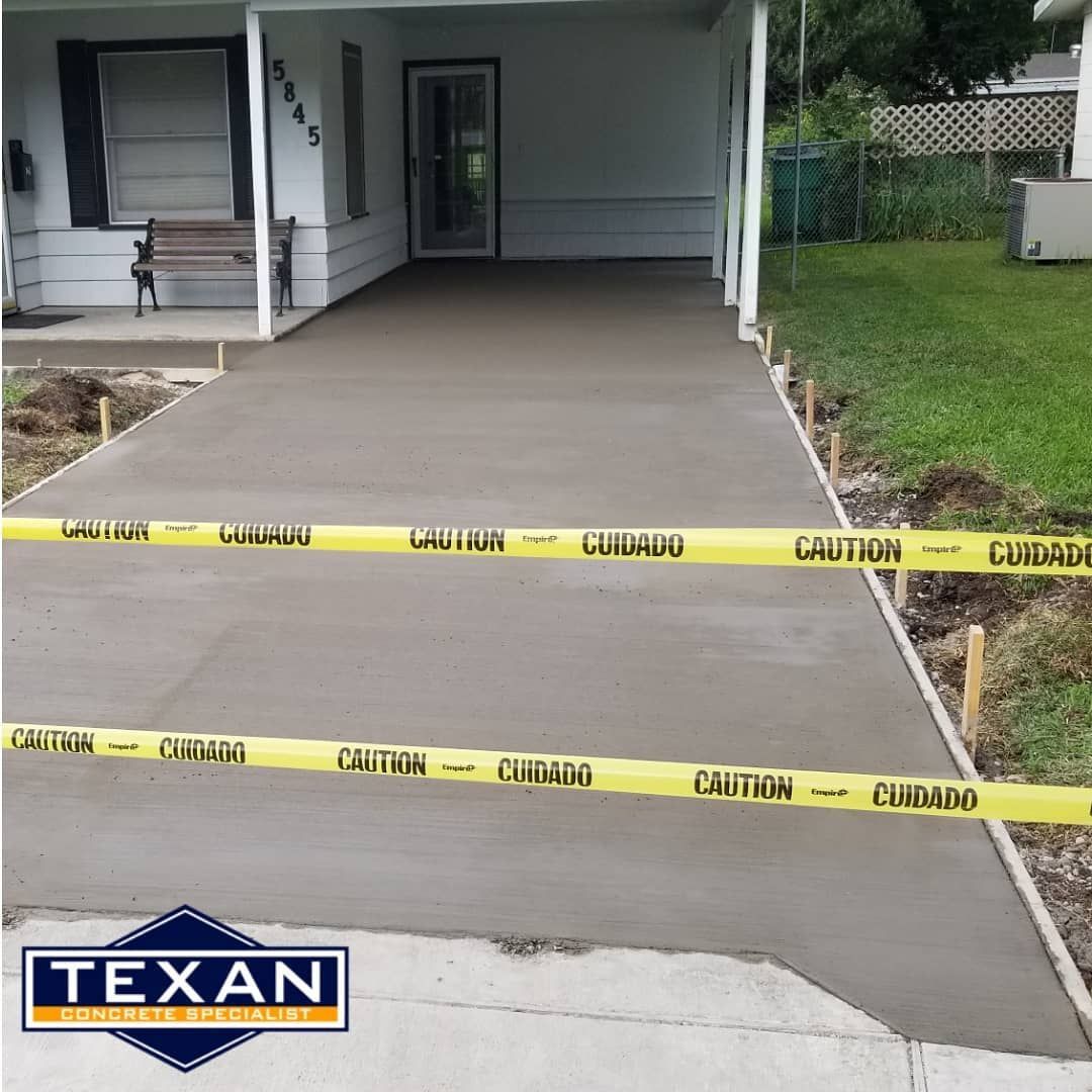 A concrete driveway is being built in front of a house