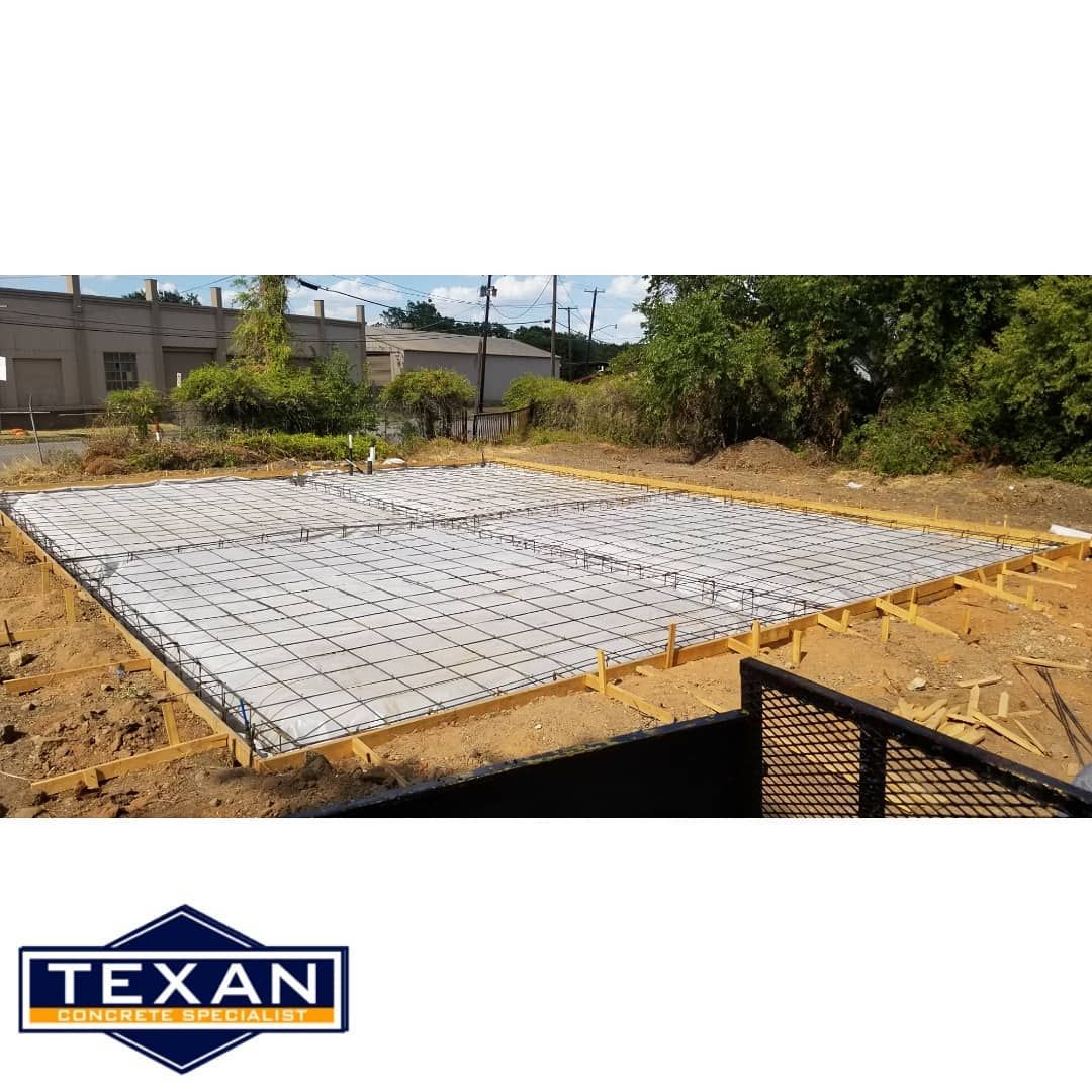 A large concrete slab is sitting on top of a dirt field.