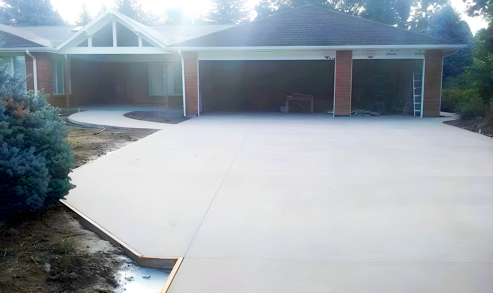 A brick house with a concrete driveway in front of it.