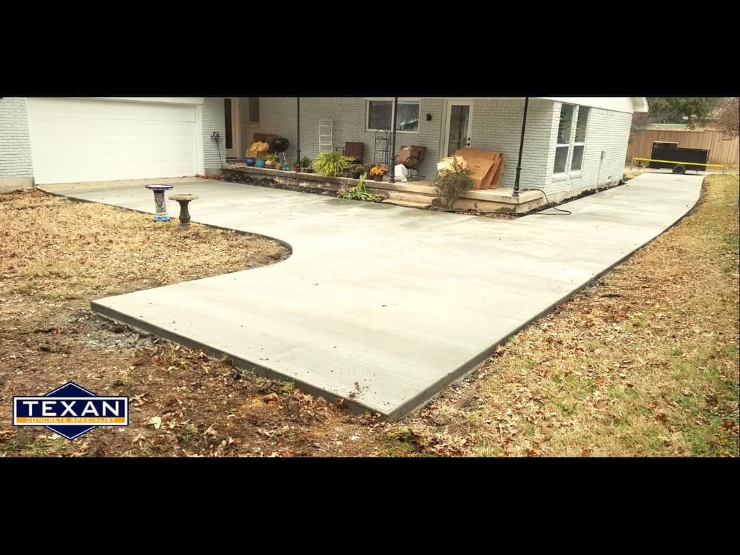 A concrete walkway is being built in front of a house.