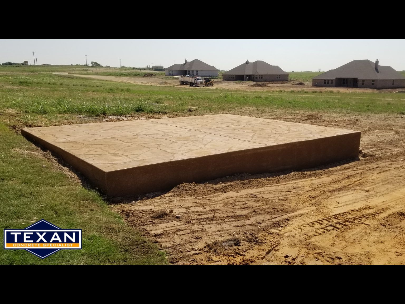 A large concrete slab is sitting in the middle of a dirt field.