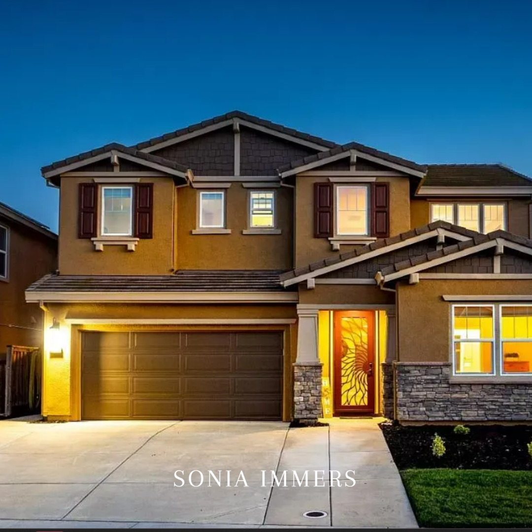Modern luxury home in Rocklin at twilight with glowing windows and stone accents. Sonia Immers - Immers Real Estate.