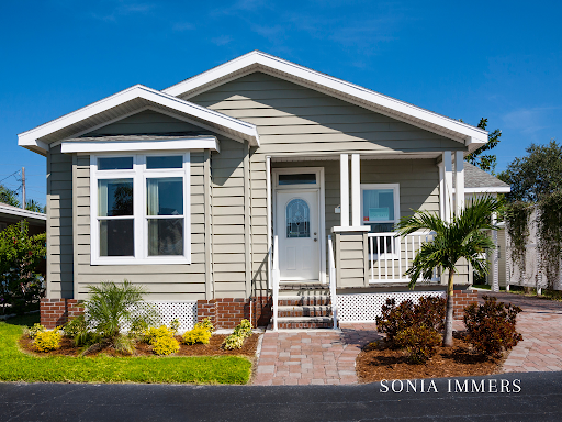 A mobile home with a porch and stairs is for sale by sonia immers
