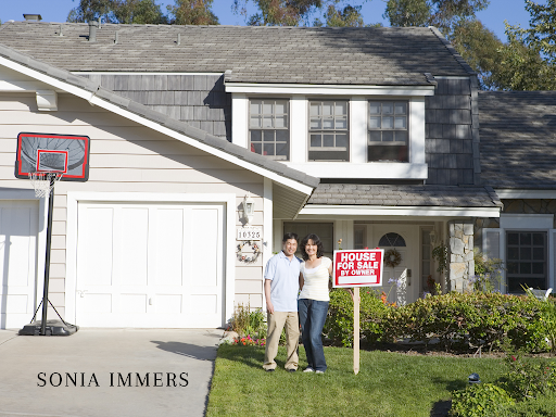 Couple standing in front of a house with a