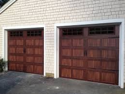 A Pair of Brown Garage Doors on A White Brick Building - Rochester Hills, MI - J & B Doors