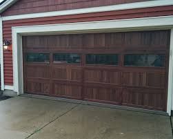 A Brown Garage Door Is Sitting in Front of A Red House - Rochester Hills, MI - J & B Doors