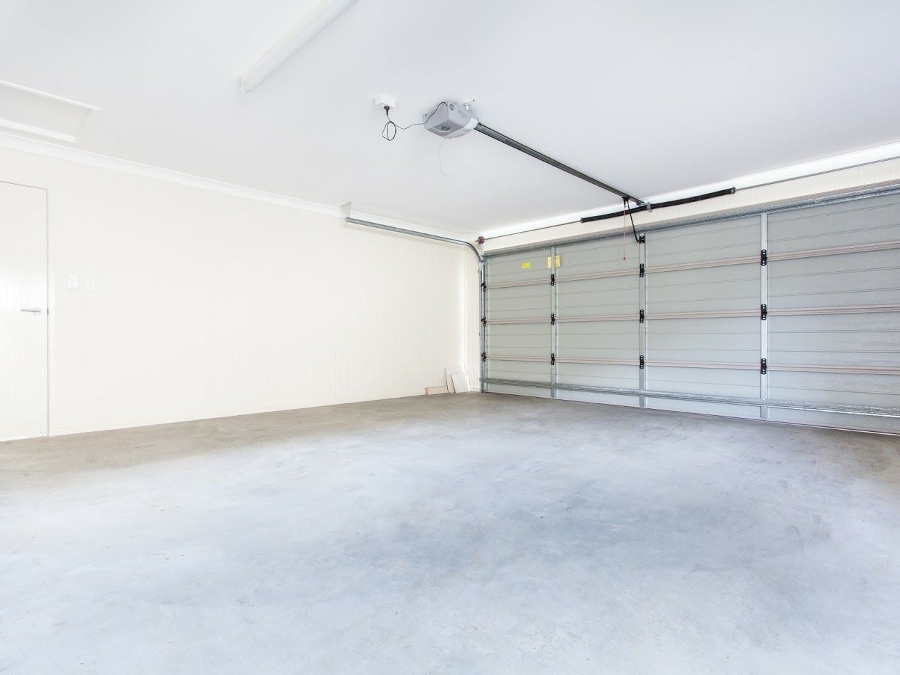 An Empty Garage with A Garage Door Open and A Ceiling Fan - Rochester Hills, MI - J & B Doors
