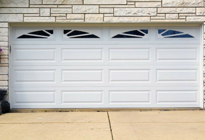 A White Garage Door Is Sitting in Front of A Brick Wall - Rochester Hills, MI - J & B Doors