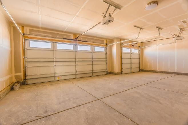An Empty Garage with A Garage Door Open and A Concrete Floor - Rochester Hills, MI - J & B Doors