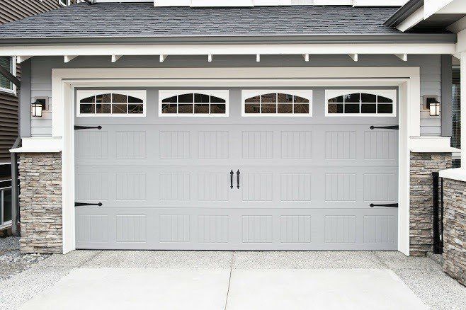 A Large Gray Garage Door Is Sitting in Front of A House - Rochester Hills, MI - J & B Doors