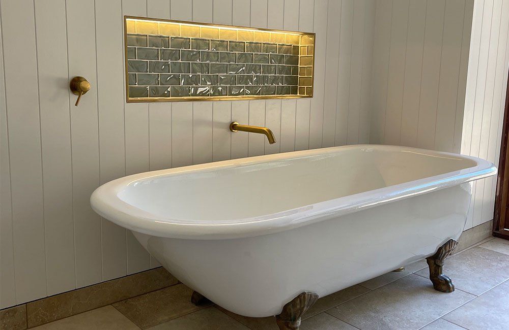 A Bathtub With A Light Accent On The Wall — Electricians in the Whitsundays, QLD